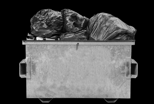 Operator loading waste into a van at a small retail clearance in Hanwell