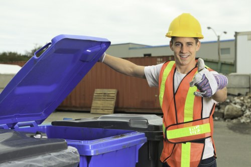 Business staff placing materials in labeled recycling bins